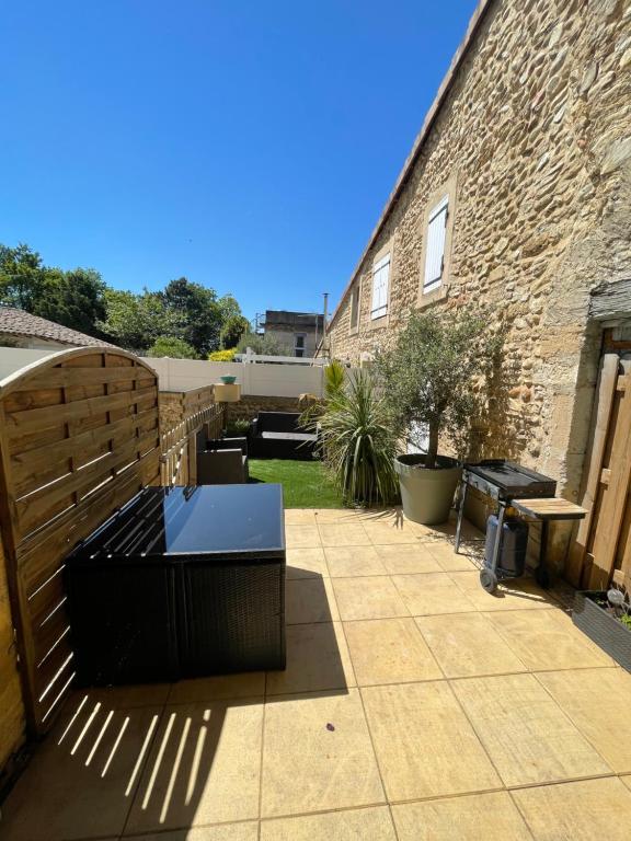 un patio avec une clôture et une table sur un patio dans l'établissement Charmante Maison de village, à Livron-sur-Drôme