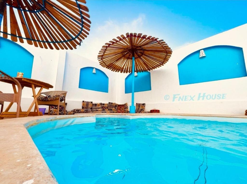 a swimming pool at a resort with an umbrella at Fnex House in Dahab