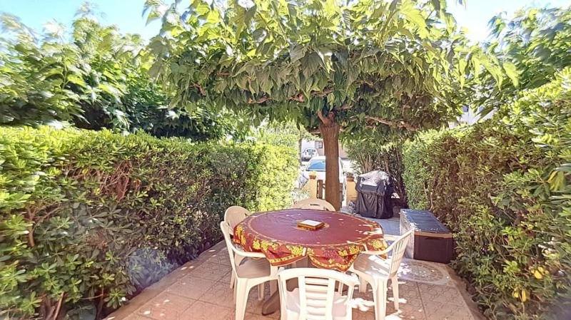 une table et des chaises assises sous un arbre dans l'établissement Appt T2 cabine RDC avec belle terrasse, à Saint Pierre La Mer