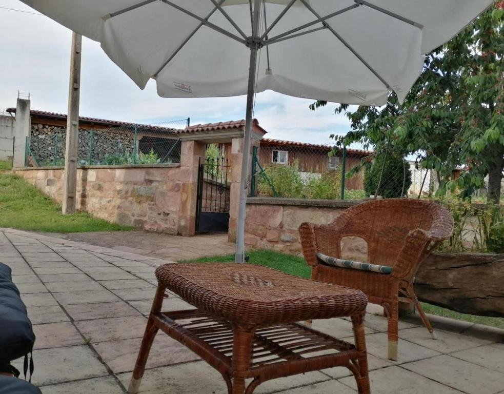 San Millán de Lara的住宿－San Pelayo，桌子和椅子,放在伞下