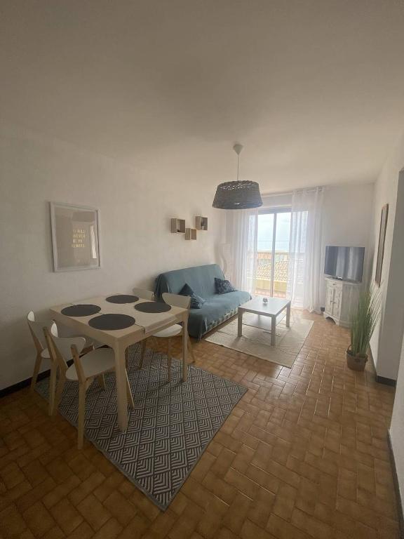 un salon avec une table et un canapé dans l'établissement Jolie appartement à 50m de la plage, à Narbonne-Plage