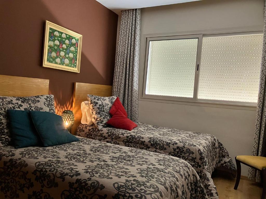 sypialnia z 2 łóżkami i oknem w obiekcie The Twins beds w mieście Nouaseur