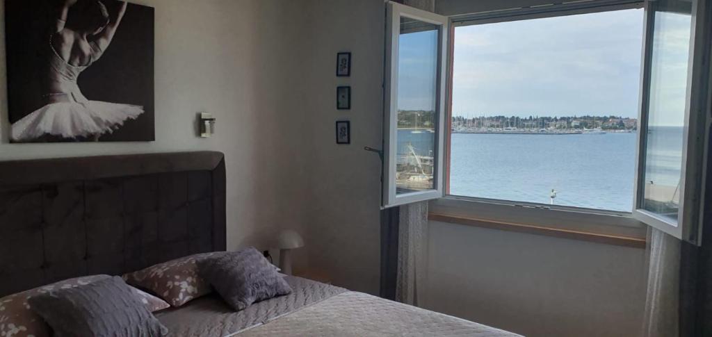 a bedroom with a bed and a view of the water at Lorena app in Umag