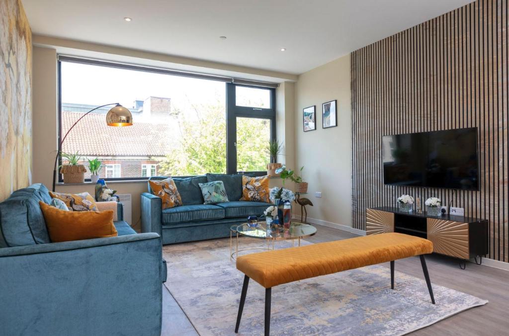 a living room with a couch and a tv at Palm Tree House - Birds of Feather in Orpington