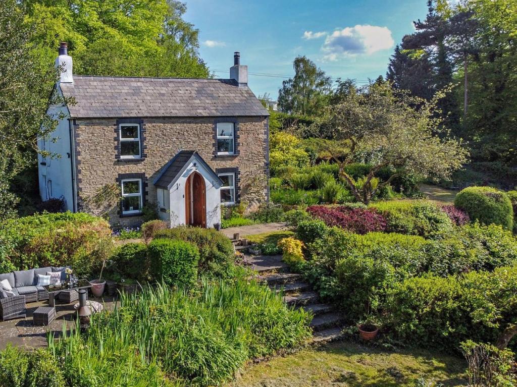 an old stone house in the middle of a garden at 3 Bed in Lydbrook 94490 in Lydbrook