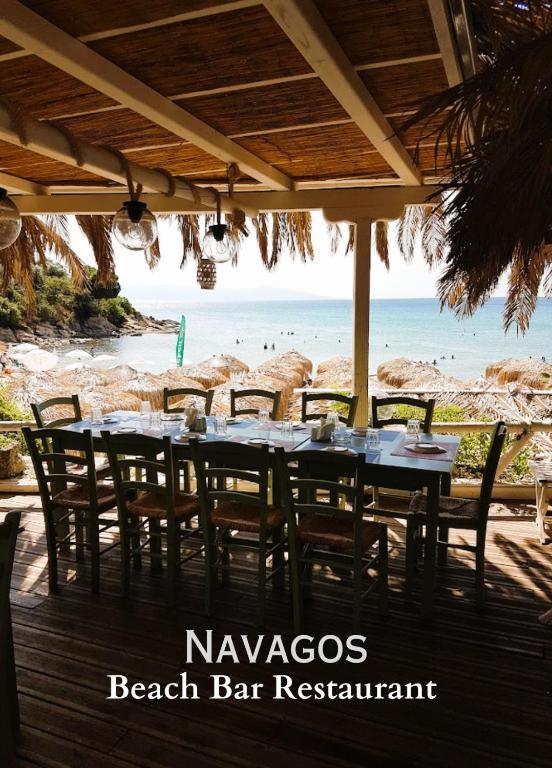 a beach bar restaurant with a table and chairs at Villa Nickolas in Paleo Tsifliki