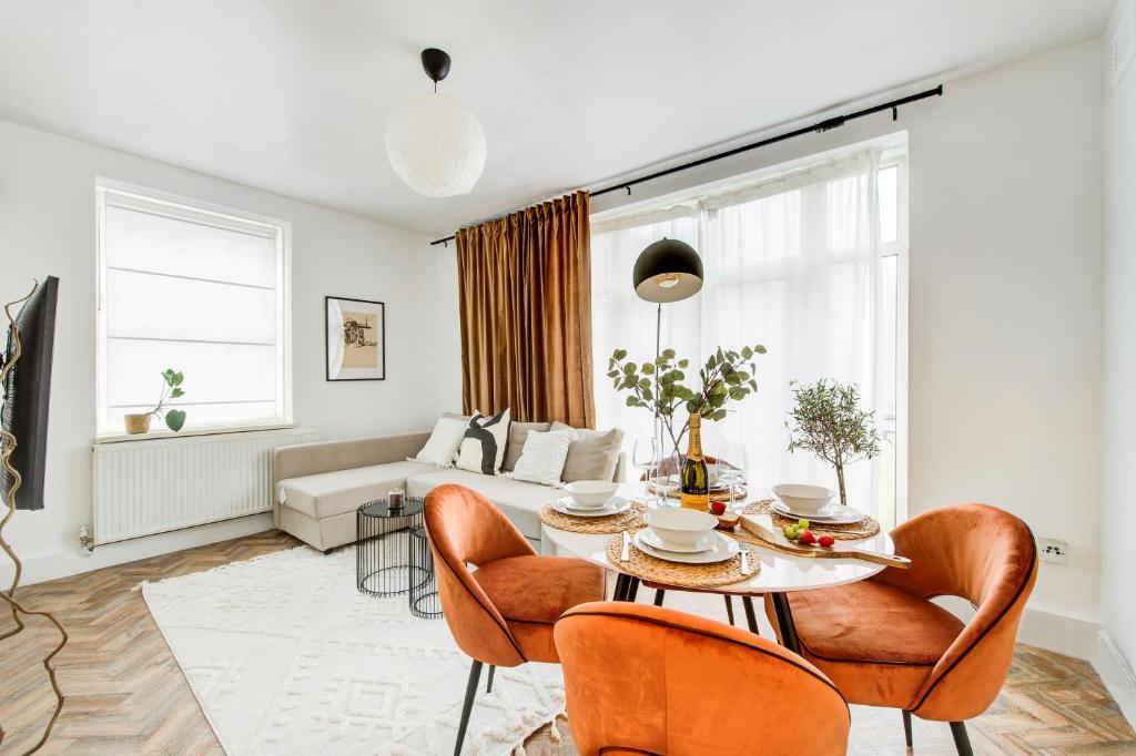 a living room with a table and chairs and a couch at BRICK LANE APARTMENT in London
