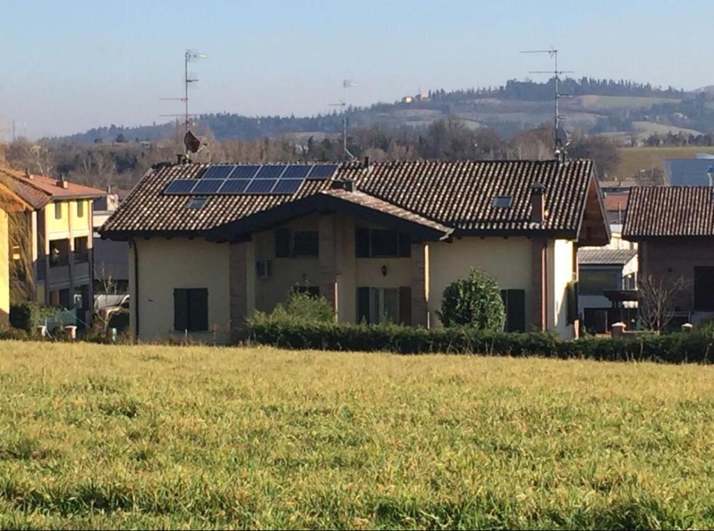 uma casa com painéis solares no topo de um campo em Villa Butik em Montecavolo