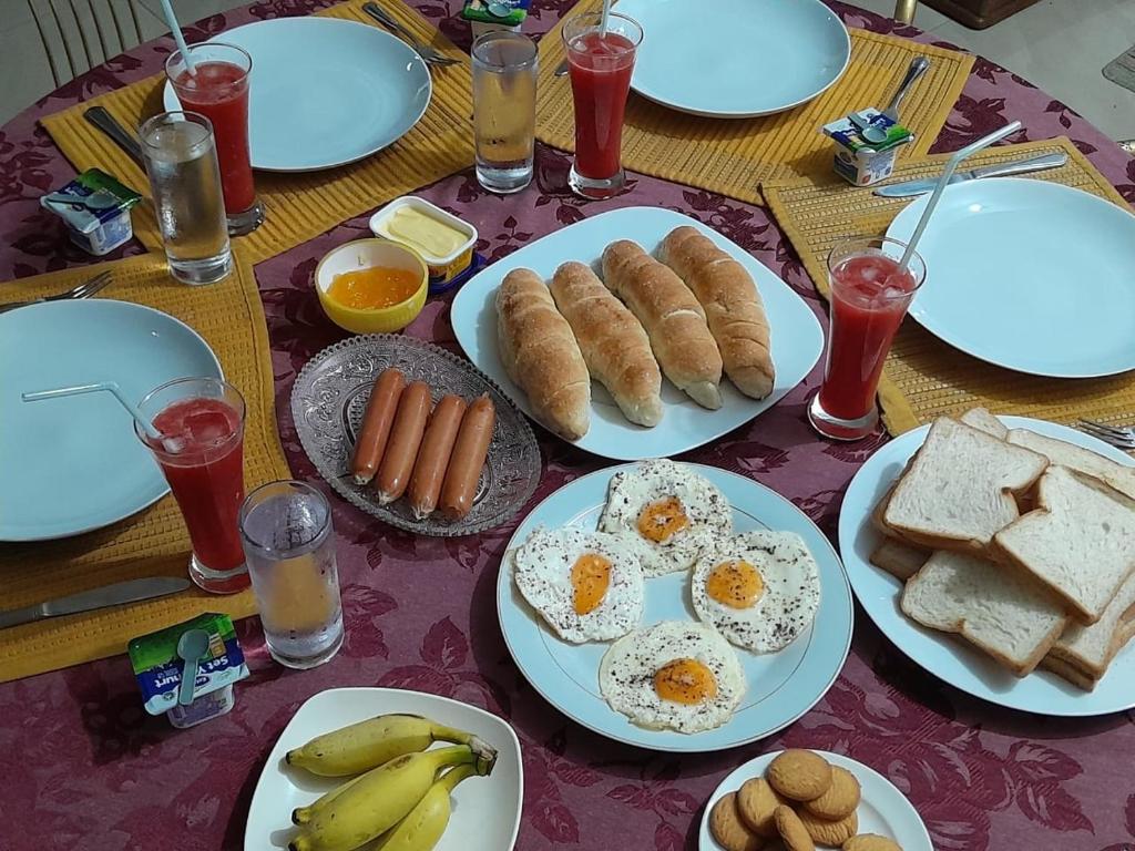 a table with plates of breakfast food on it at Leisure home in Colombo
