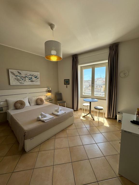 a bedroom with a bed and a table and a window at San Pietro Otranto in Otranto