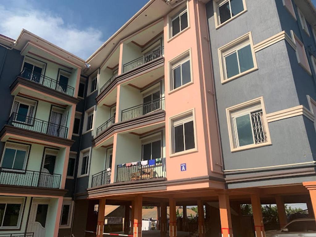 a large apartment building with balconies on a street at Beautiful 2-Bed Apartment in Kampala in Jinja