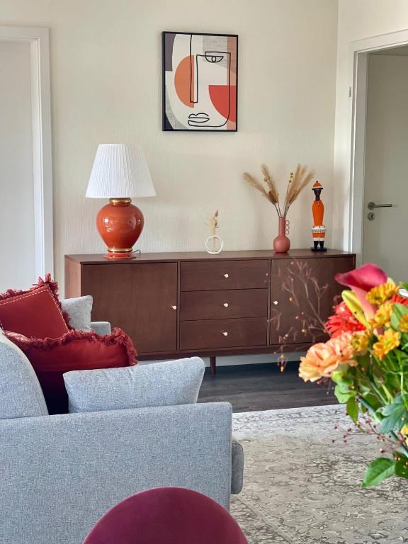 - un salon avec un canapé et une commode dans l'établissement Cosy-Rent Appartement de standingparking Neudorf, à Strasbourg