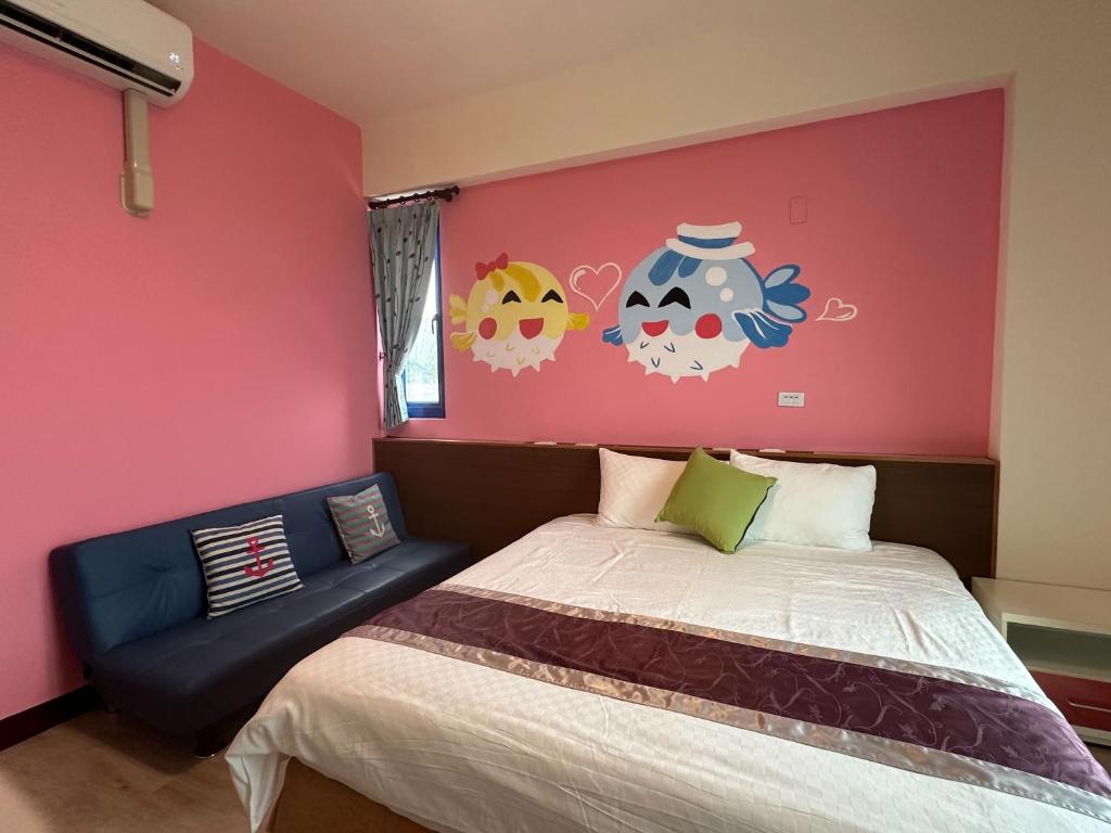 a bedroom with a bed and a pink wall at Blue Bay in Green Island