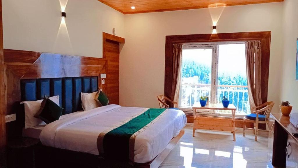 een slaapkamer met een groot bed en een groot raam bij HOTEL THE PINE VILLA MUSSOORIE in Mussoorie