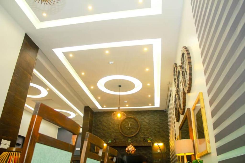 - un couloir avec un plafond orné d'un lustre dans l'établissement La pépite, à Cotonou