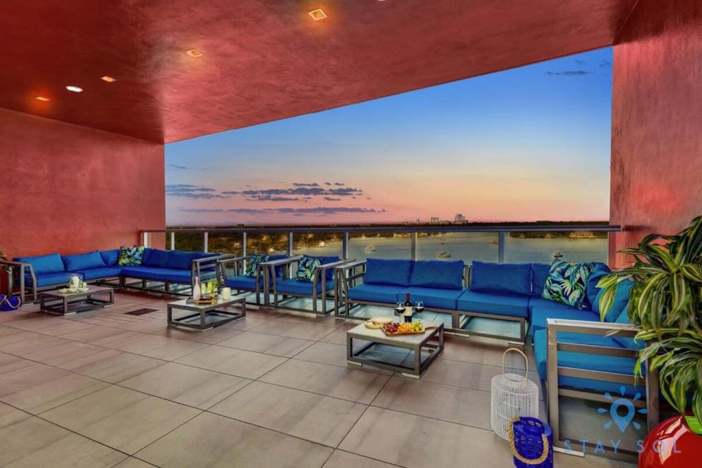 a large living room with blue couches and tables at Hollywood Bliss Studio Balcony Beach View in Hollywood