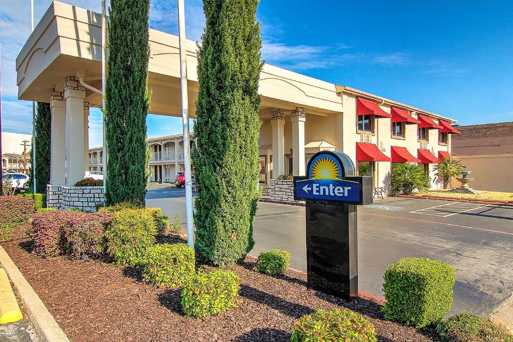 un hotel con un cartel frente a un edificio en Days Inn by Wyndham Market Center Dallas Love Field, en Dallas