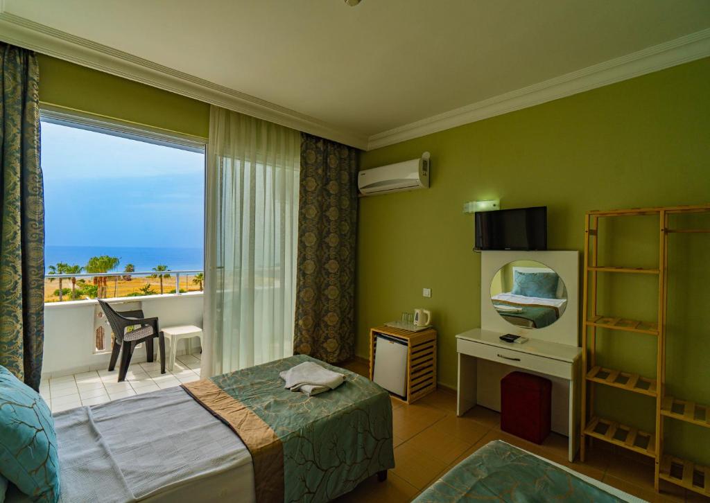 a bedroom with a bed and a window with a balcony at DE MARE FAMILY Hotel in Konaklı