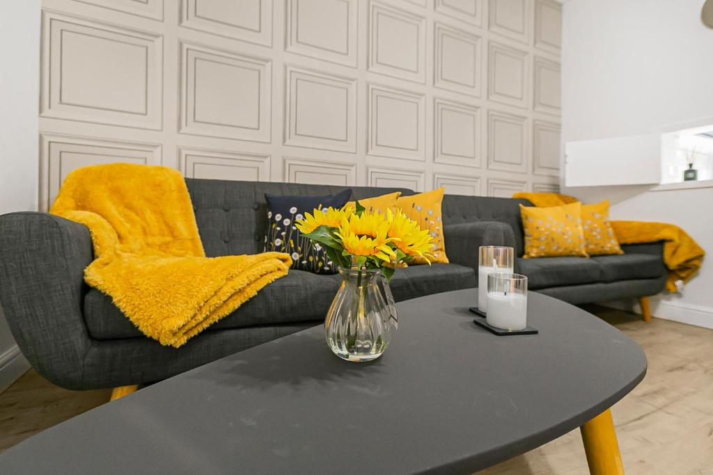 a living room with a couch and a table with yellow pillows at Casa Dolce in London