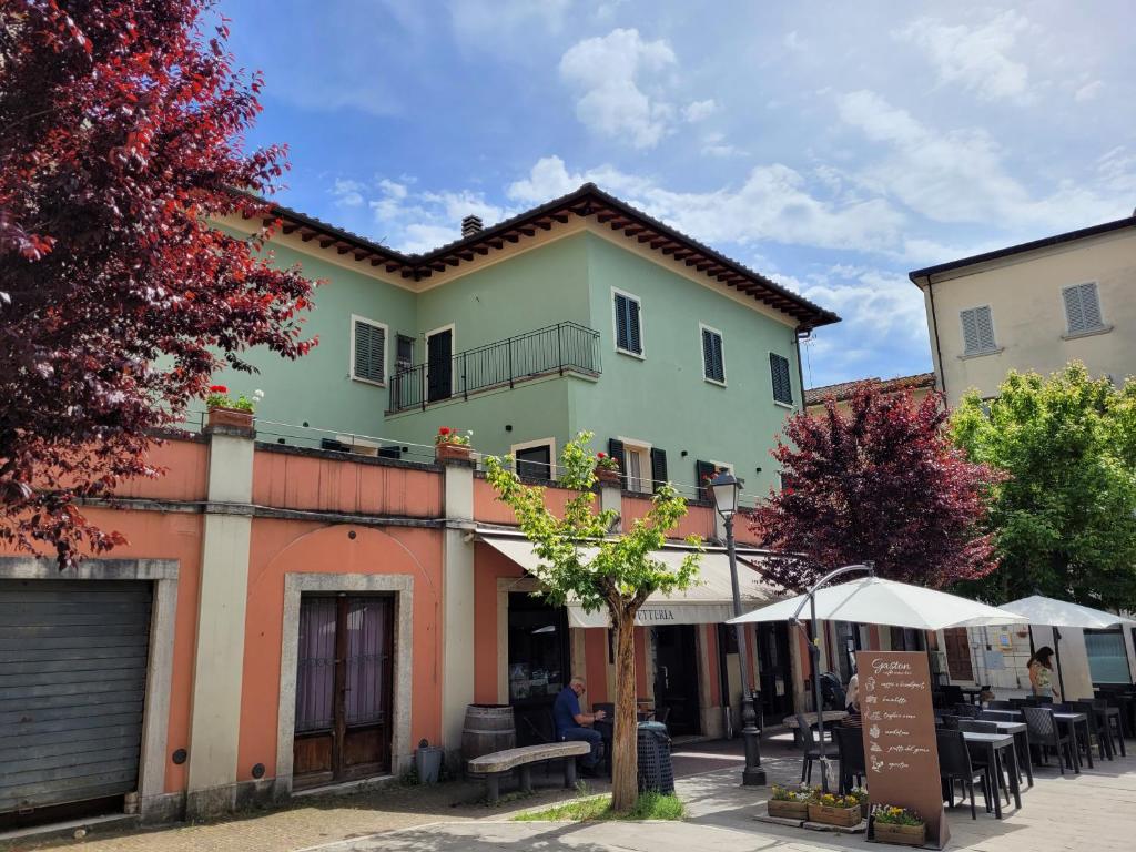 アシャーノにあるCasa in Piazzaの目の前にテーブルと椅子が置かれた建物