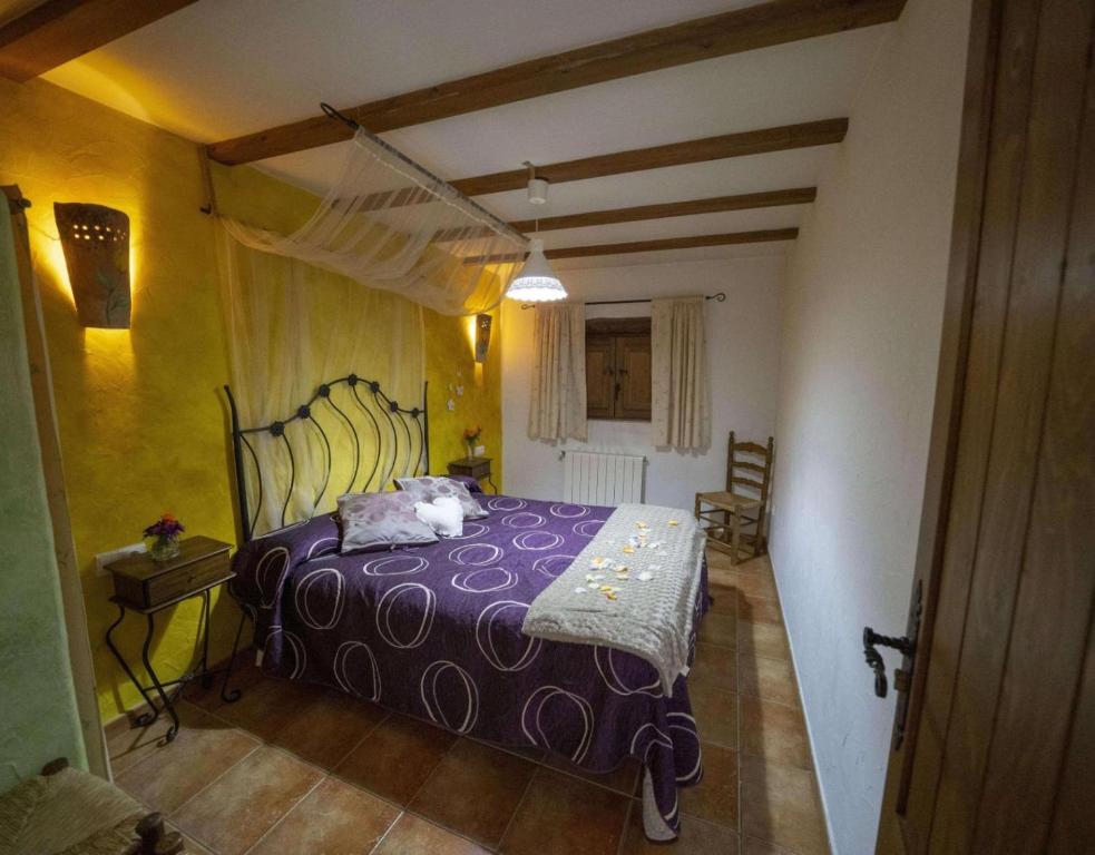 a bedroom with a purple bed in a room at Casa Rural Padre Ramon in Laroya