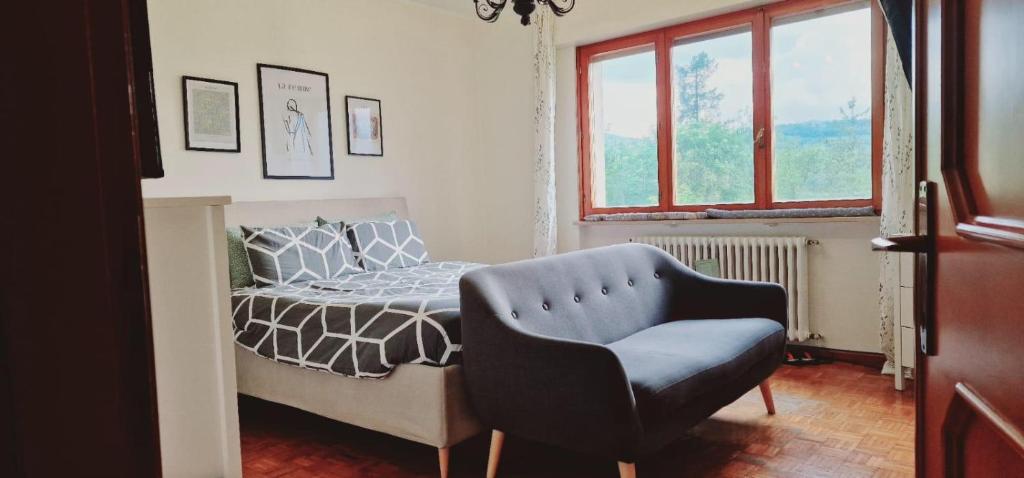 una camera con un letto e una sedia e una finestra di Villa Debora a Ponte nellʼAlpi