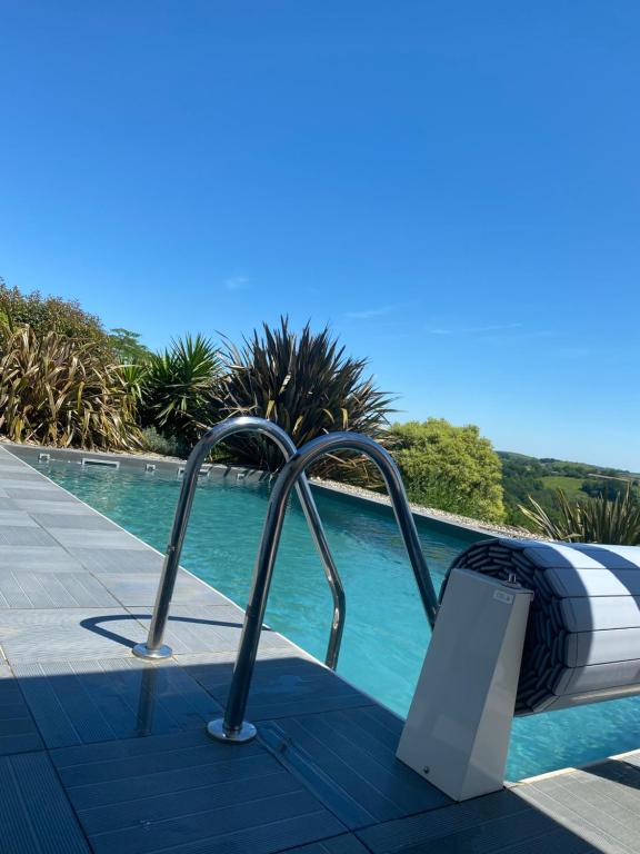 un lit est à côté d'une piscine dans l'établissement Entre mer et montagne AMA LUR, à Hasparren