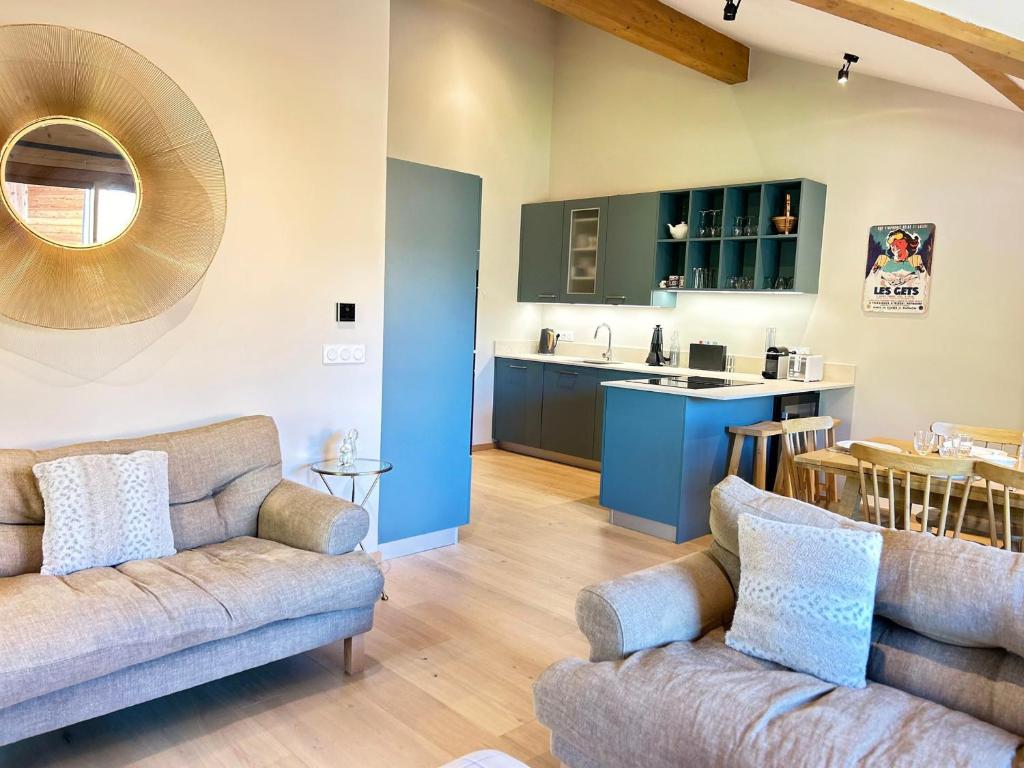 un salon avec deux canapés et une cuisine dans l'établissement Appartement de standing - 3 chambres, balcons, garage, proche centre et remontées mécaniques - FR-1-623-357, aux Gets