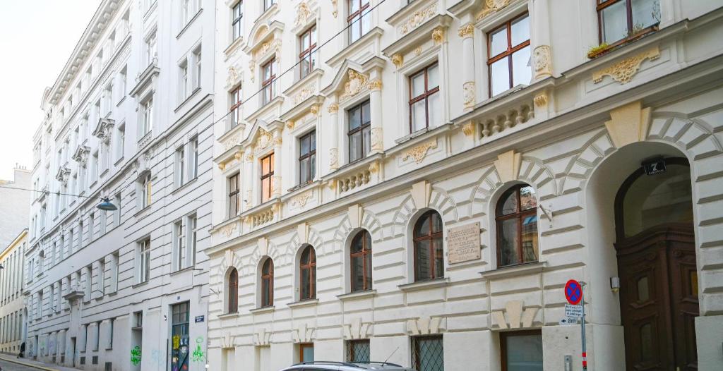 ein großes weißes Gebäude mit vielen Fenstern auf einer Straße in der Unterkunft Exclusive Suite Museumsquartier in Wien