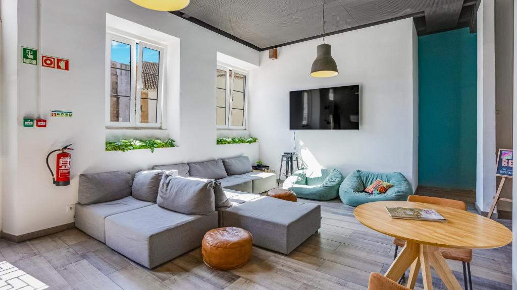 uma sala de estar com um sofá e uma mesa em Hostellicious em Faro