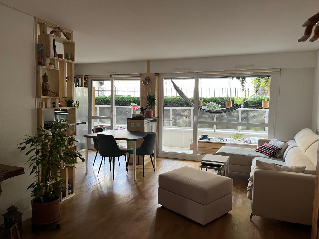 un salon avec un canapé et une table dans l'établissement 2 chambres avec petit-déjeuner, à Pantin