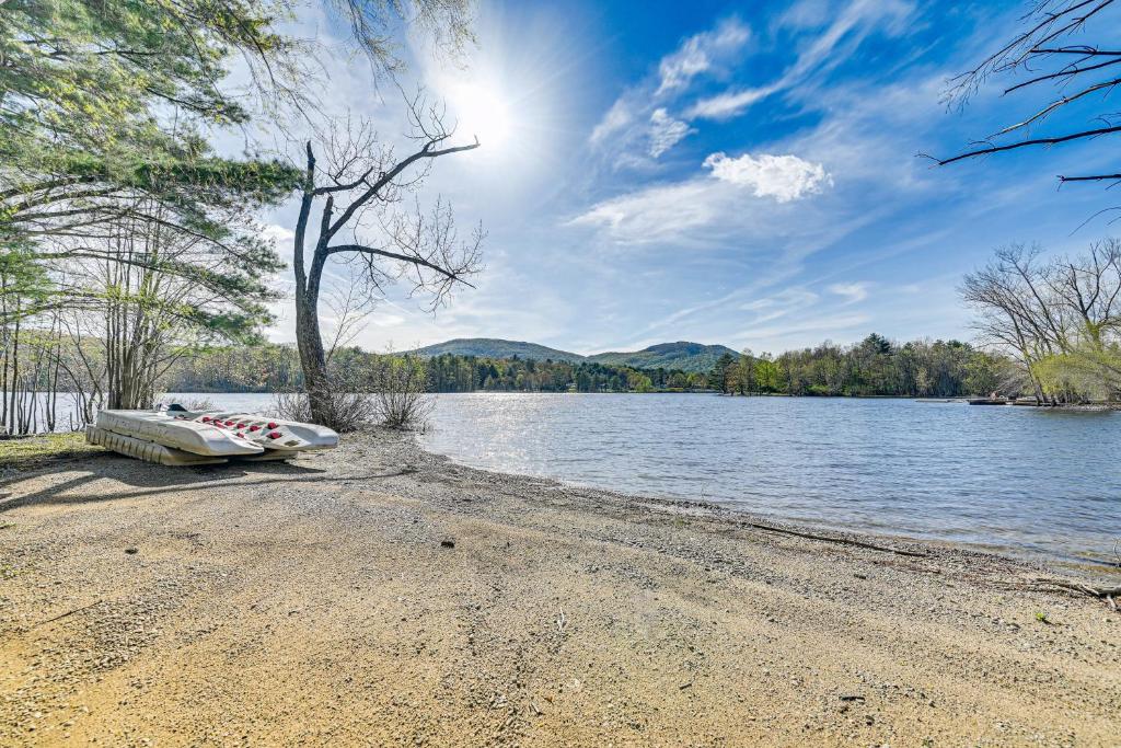 a boat sitting on the shore of a lake at Fire Pit and Beach Access Quiet Northville Retreat in Benson
