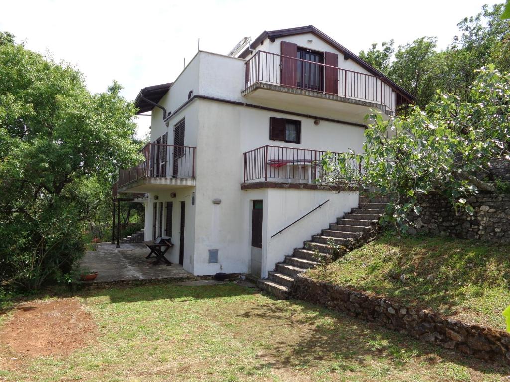 a white house with stairs and balconies on it at Apartmani Marina in Labin