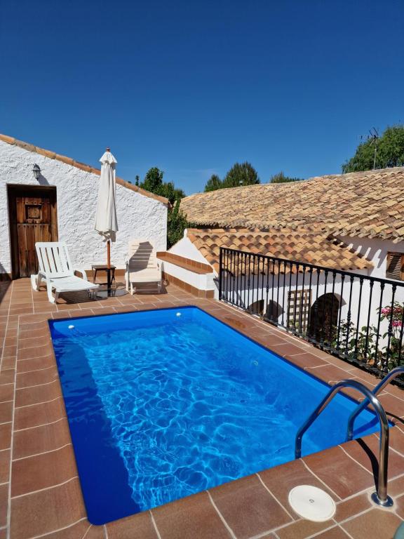 Venta de Micena的住宿－Cortijo Romero，房屋庭院内的游泳池