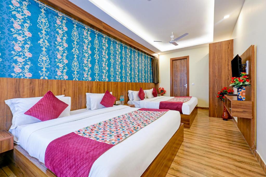 a hotel room with two beds and a tv at Wood Rose Hotel Near Delhi Airport in New Delhi