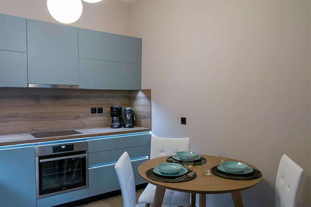 a kitchen with a table and chairs and a kitchen with a counter at Koukounaraki Apartment 1 in Skiathos
