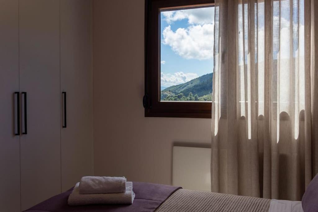 a bedroom with a window with a towel on a bed at Koukounaraki Apartment 1 in Skiathos