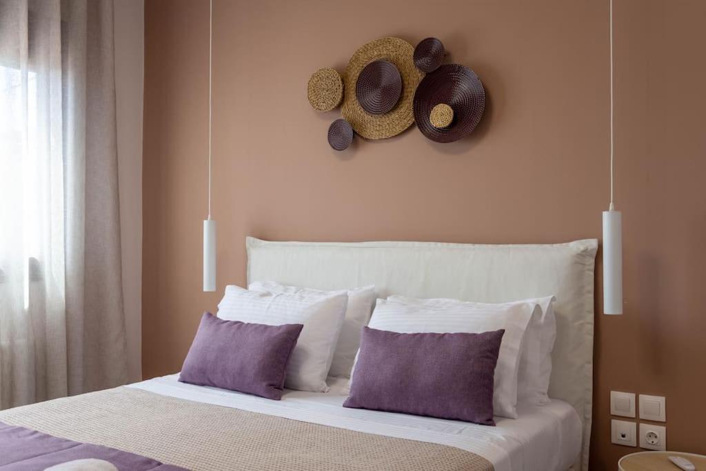 a bedroom with a bed with pillows and hats on the wall at Koukounaraki Apartment 1 in Skiathos