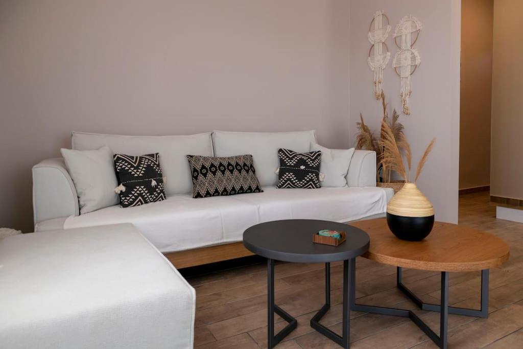 a living room with a white couch and a table at Koukounaraki Apartment 1 in Skiathos