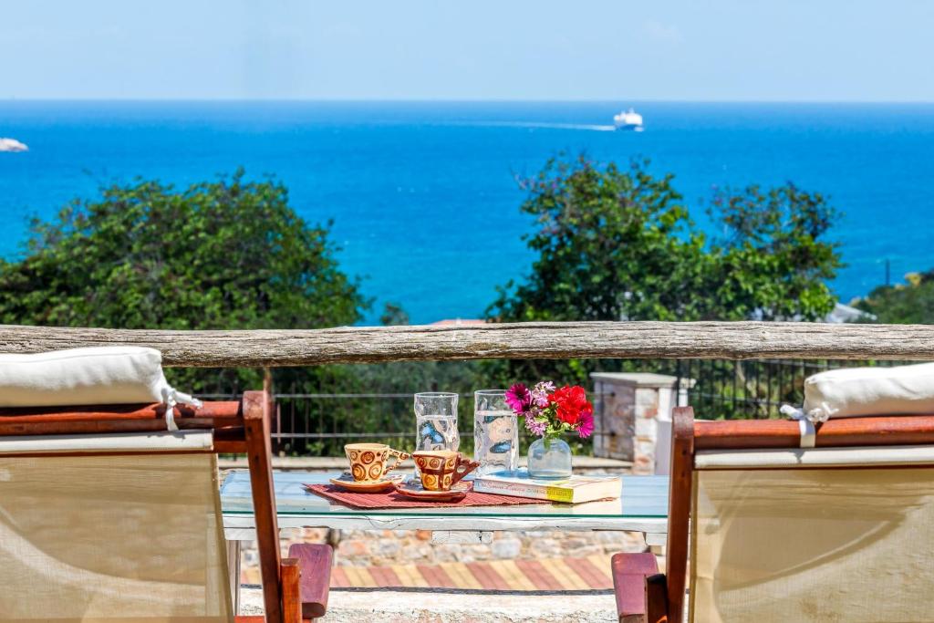 un tavolo su un balcone con vista sull'oceano di Naiades superior apartments in Skopelos with sea view close to the town a Skopelos Town