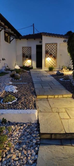 a house with a stone walkway in front of it at Koukounaraki Apartment 1 in Skiathos
