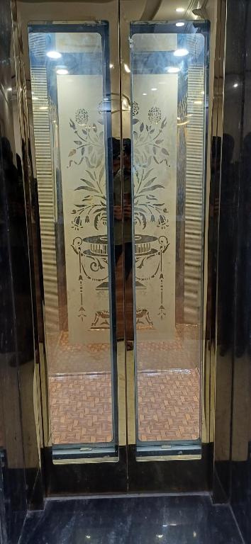 a display case with two glass doors with flowers on it at Pavan Guest Inn in Vrindāvan