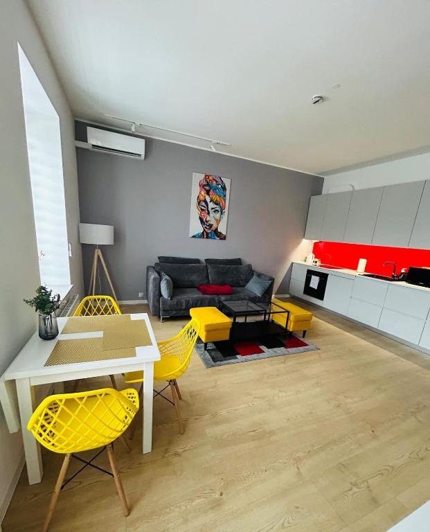a living room with a table and yellow chairs at Apartment Targowa L10 in Lublin