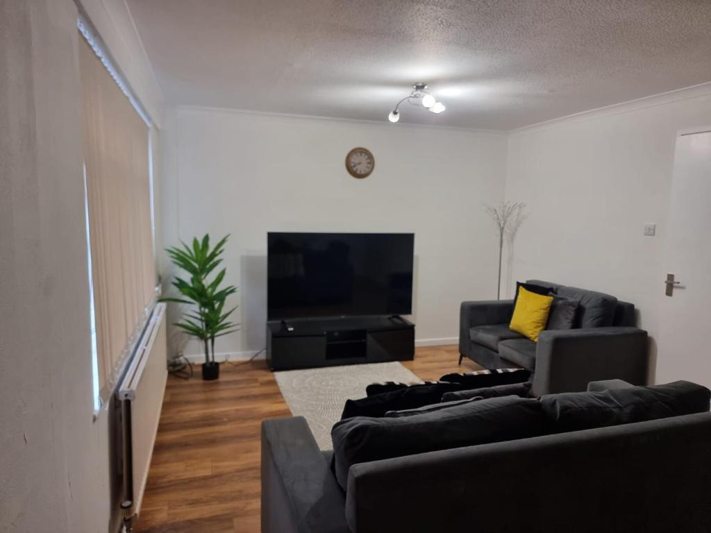 een woonkamer met 2 banken en een flatscreen-tv bij Rehoboth Living in Thamesmead