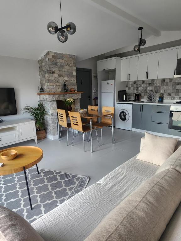 a kitchen and living room with a couch and a table at White coral house in Dalaman