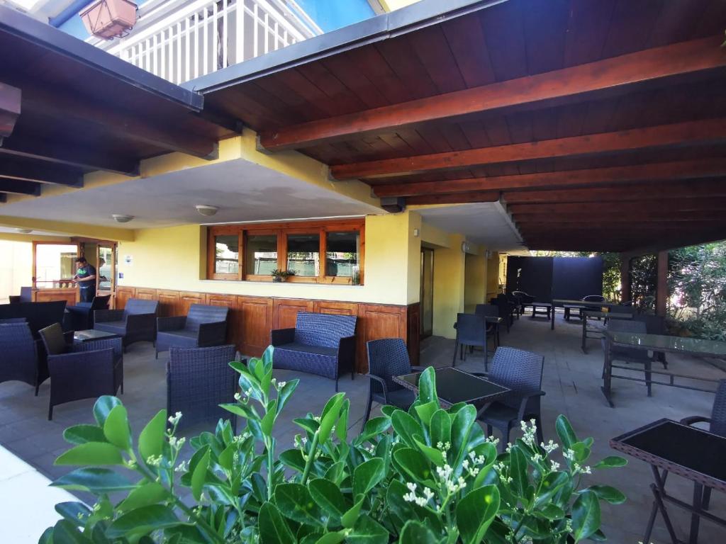 un patio in un ristorante con sedie e tavoli di Hotel Prestige 3 Stars a Rimini