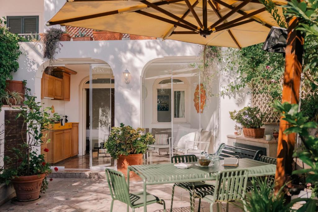 a patio with a table and chairs and an umbrella at 23Baci, Capri in Capri