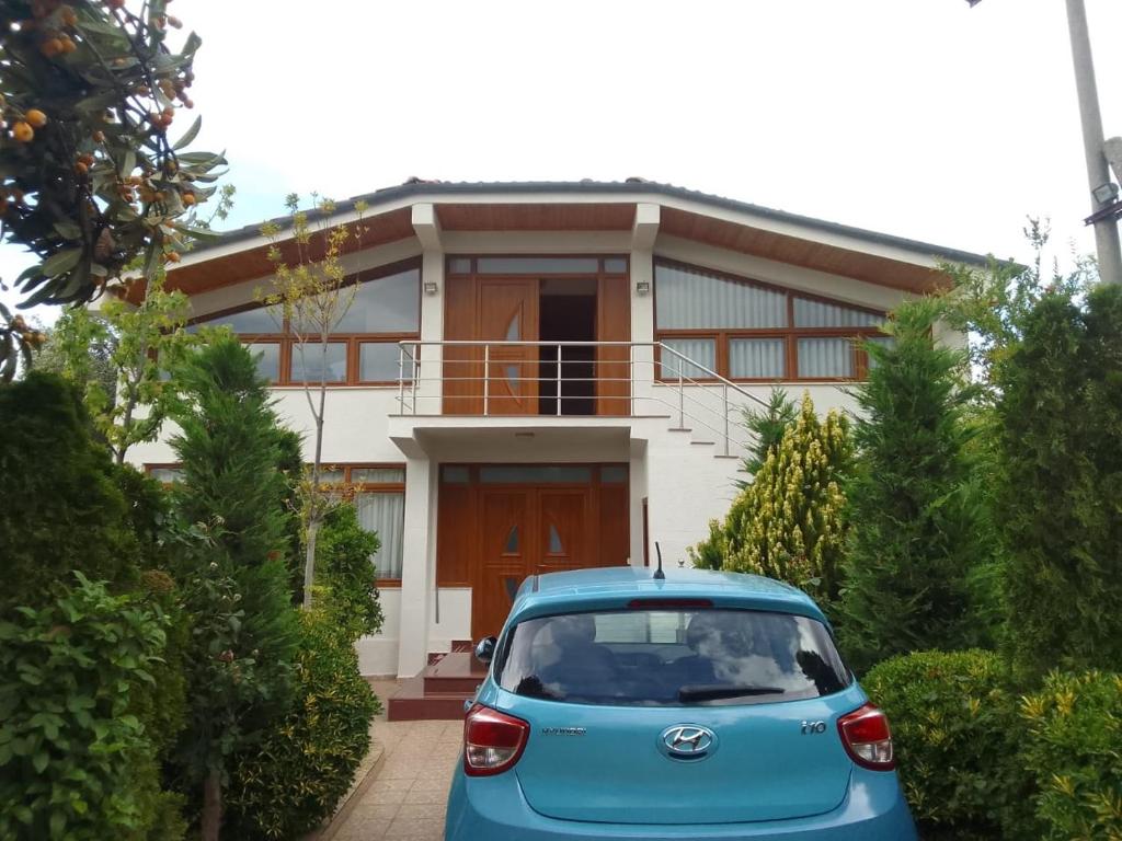 um carro azul estacionado em frente a uma casa em Akid&Alan Apartment em Tirana