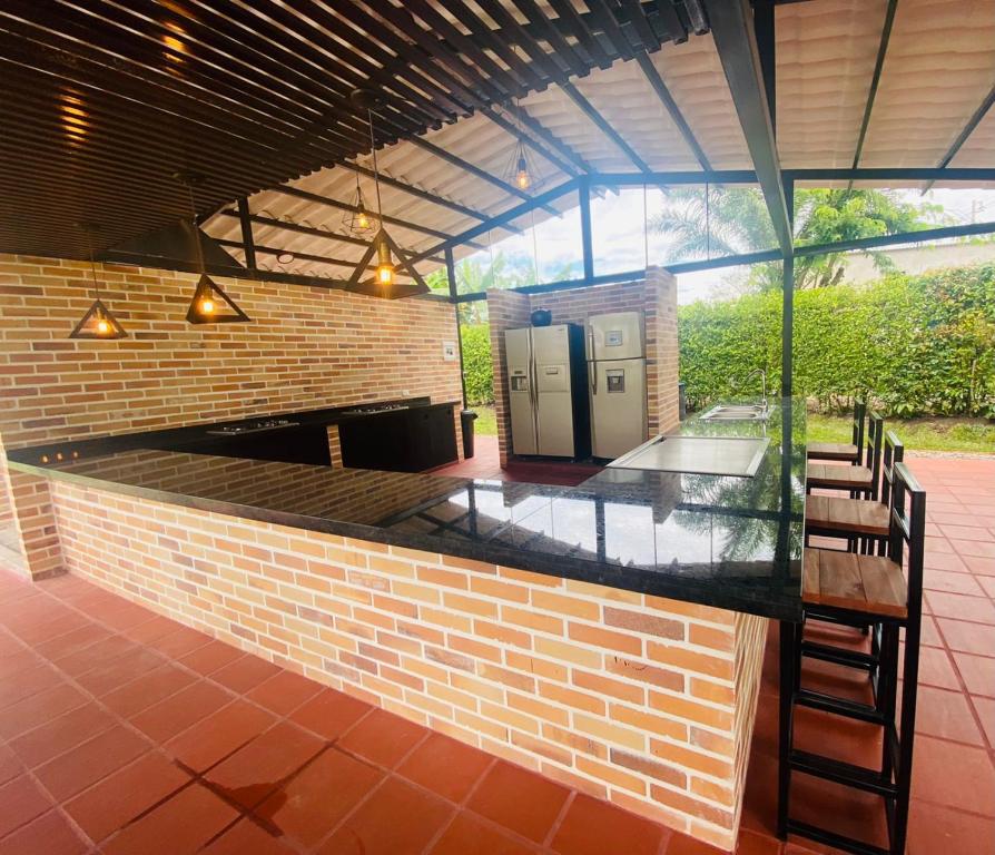 un bar al aire libre con sillas y una pared de ladrillo en Finca El Descanso en Villavicencio