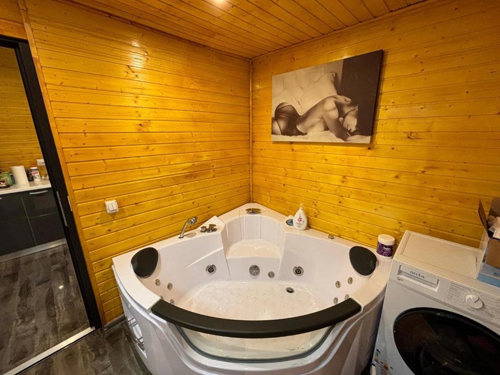 een badkamer met een ligbad en houten wanden bij Cabana revitalizarii 